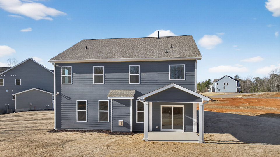 Two story home with blue colored siding with a back patio