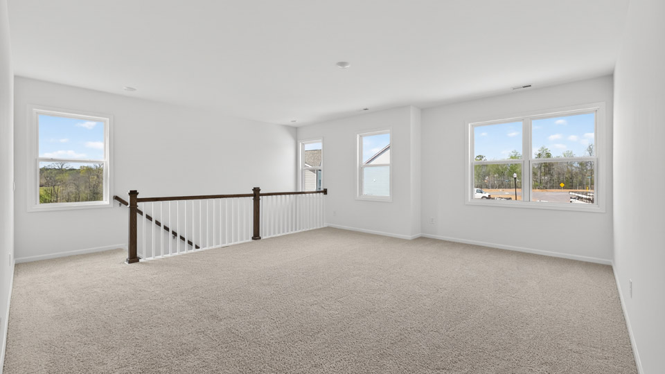 upstairs loft area with large windows and carpeting