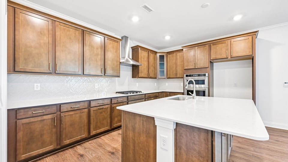 kitchen with quartz counters, kitchen island, pantry, stainless steel appliances