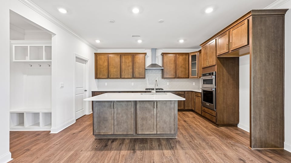kitchen with quartz counters, kitchen island, pantry, stainless steel appliances