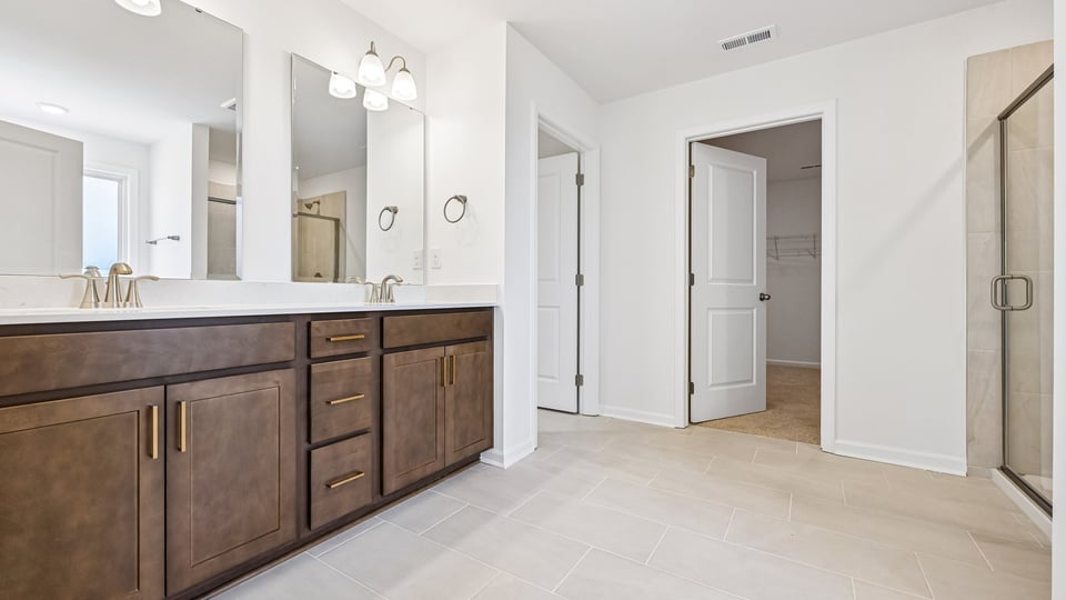 primary bathroom with walk in shower, bathtub, and dual vanity sinks