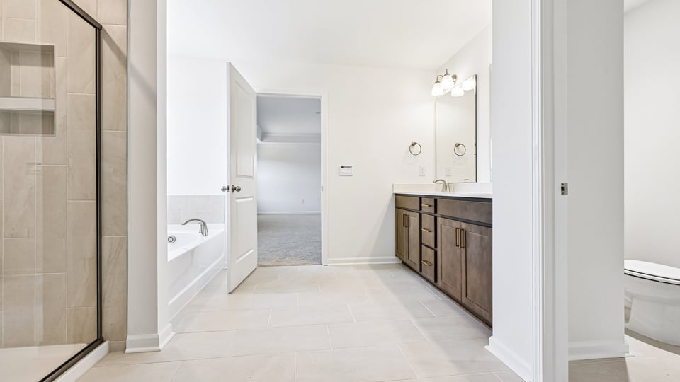 primary bathroom with walk in shower, bathtub, and dual vanity sinks
