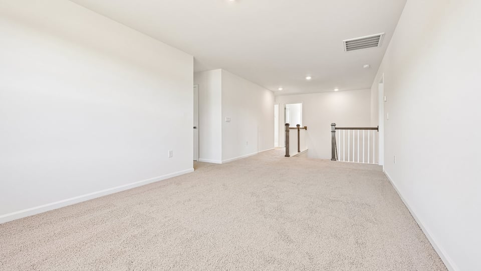 upstairs loft area with large windows and carpeting