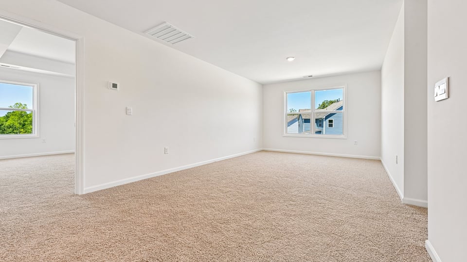 upstairs loft area with large windows and carpeting