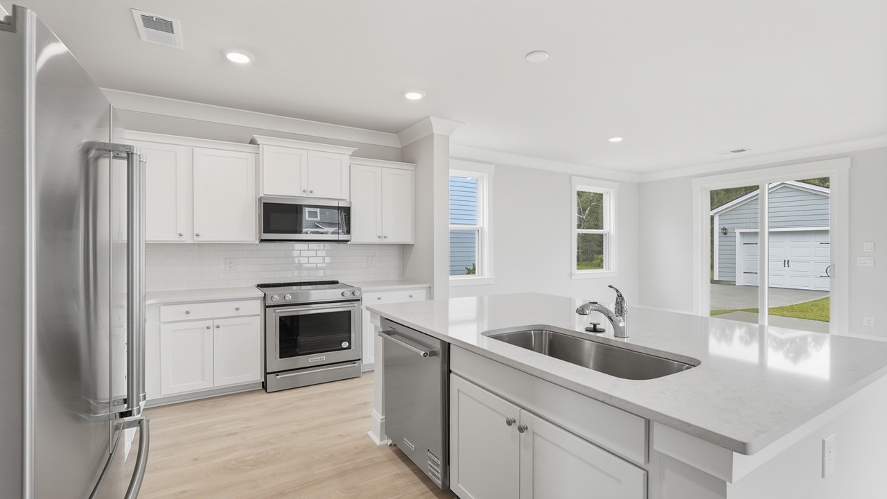 open concept kitchen with quartz and white cabinets