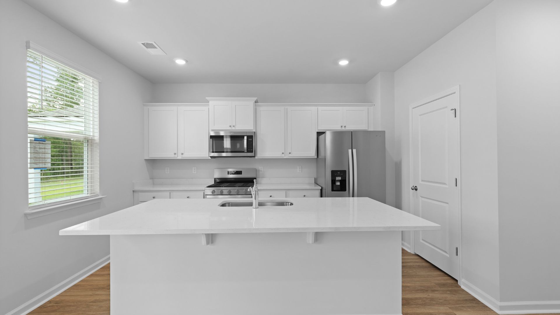 Quartz island and countertops in the kitchen with white cabinets