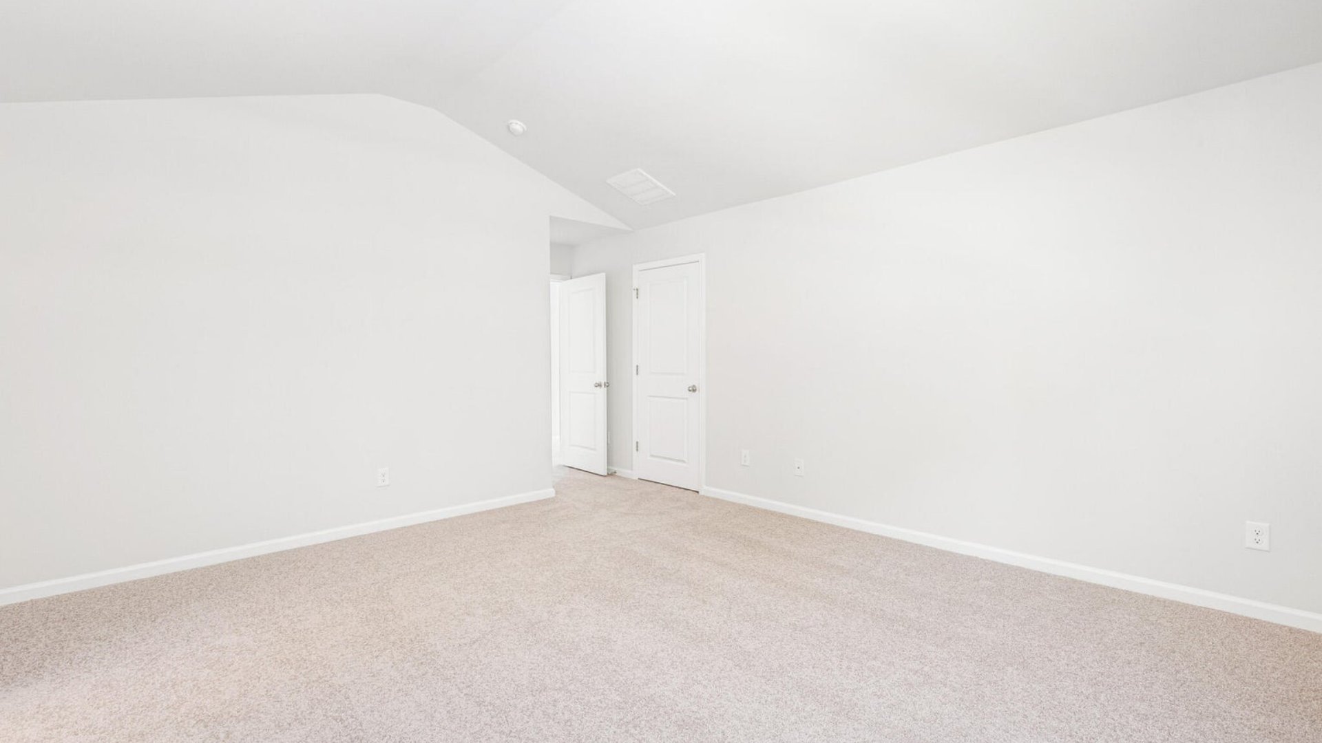 The primary bedroom is spacious and bright from windows.