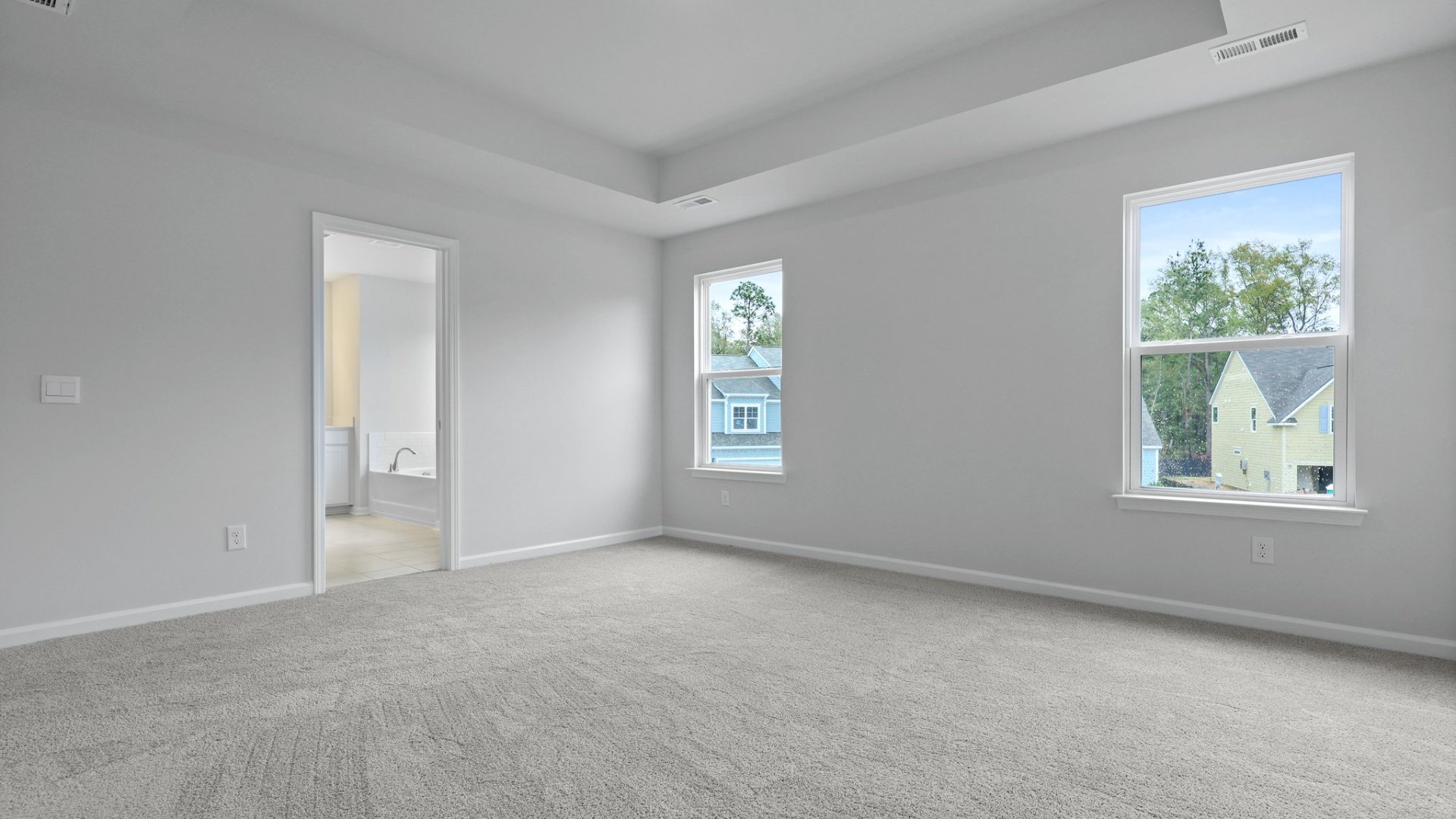 The primary bedroom has natural lighting from windows.