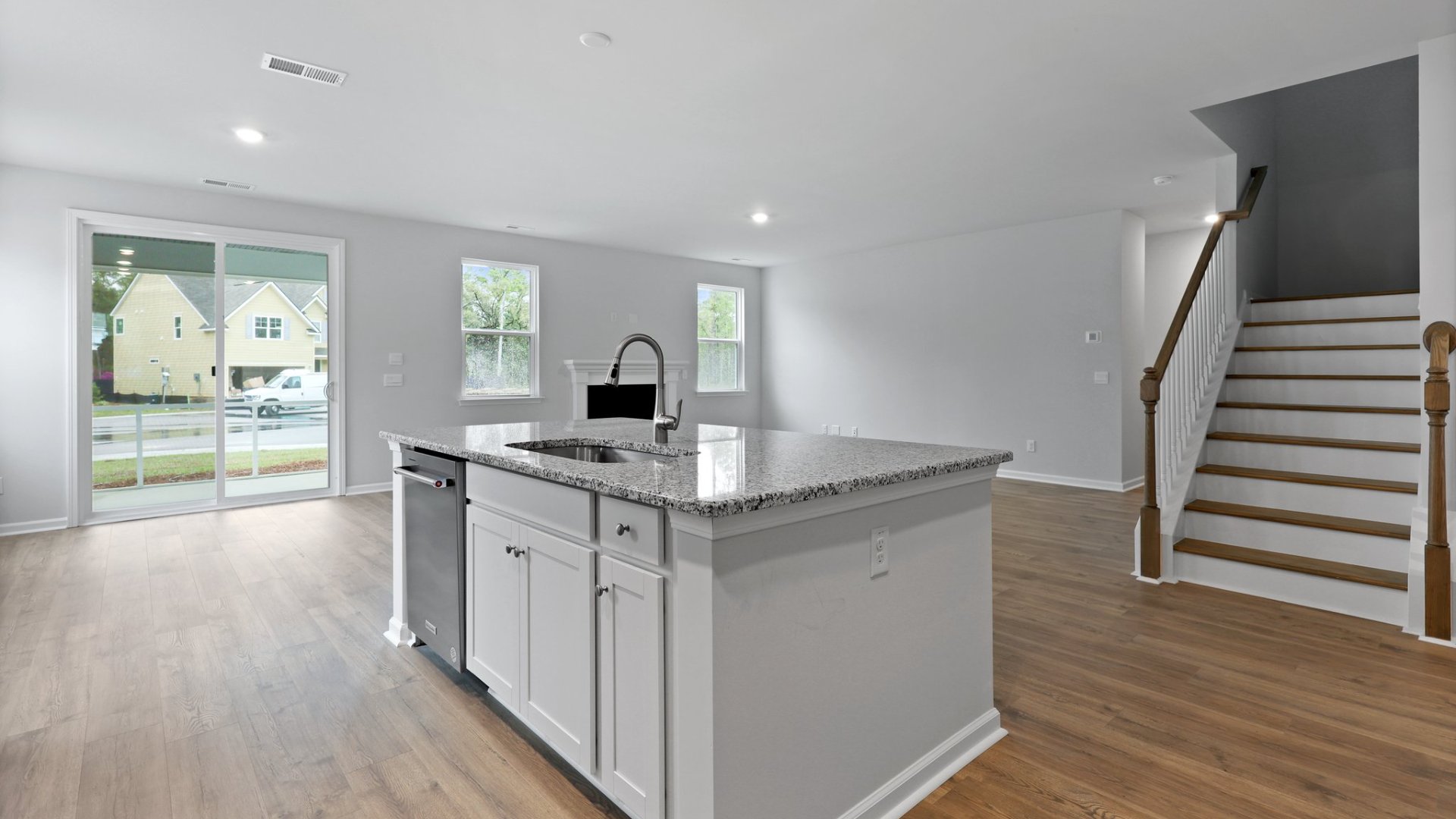 The staircase is located across from the kitchen.