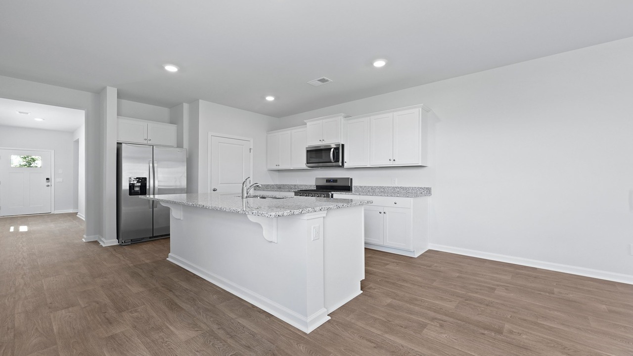 Modern kitchen showcasing white cabinetry, quartz counters, and ample workspace.