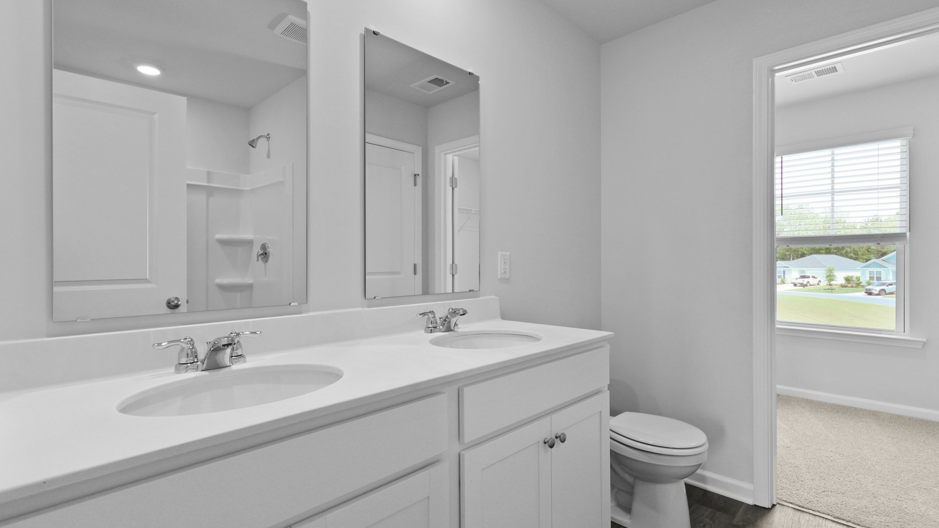 The primary bathroom has double vanities and the closet is located within.