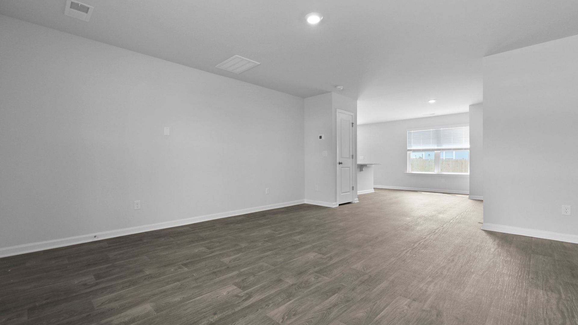 The living room is full of natural light from the large win