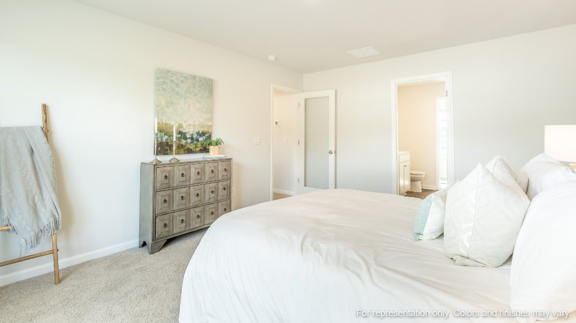 The primary bedroom is well-lit with natural lighting from the windows.