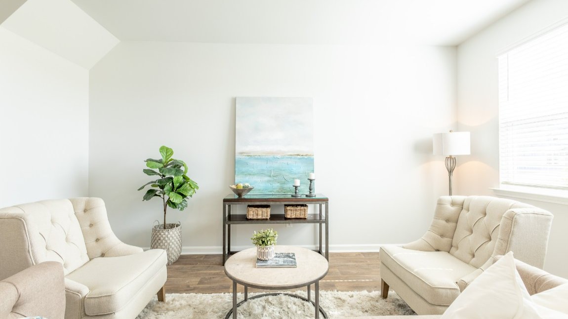 There are large windows that bring natural lighting to the living room.