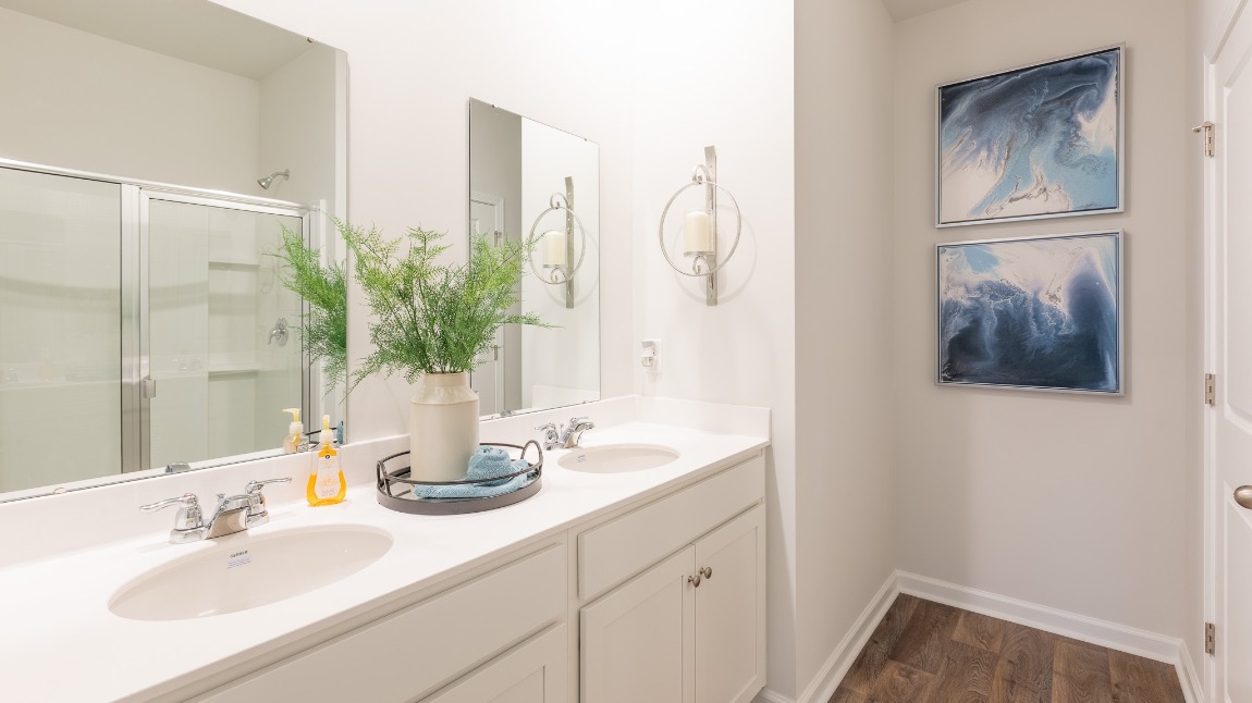 Double vanities in the private primary bathroom with a standup walk-in shower.