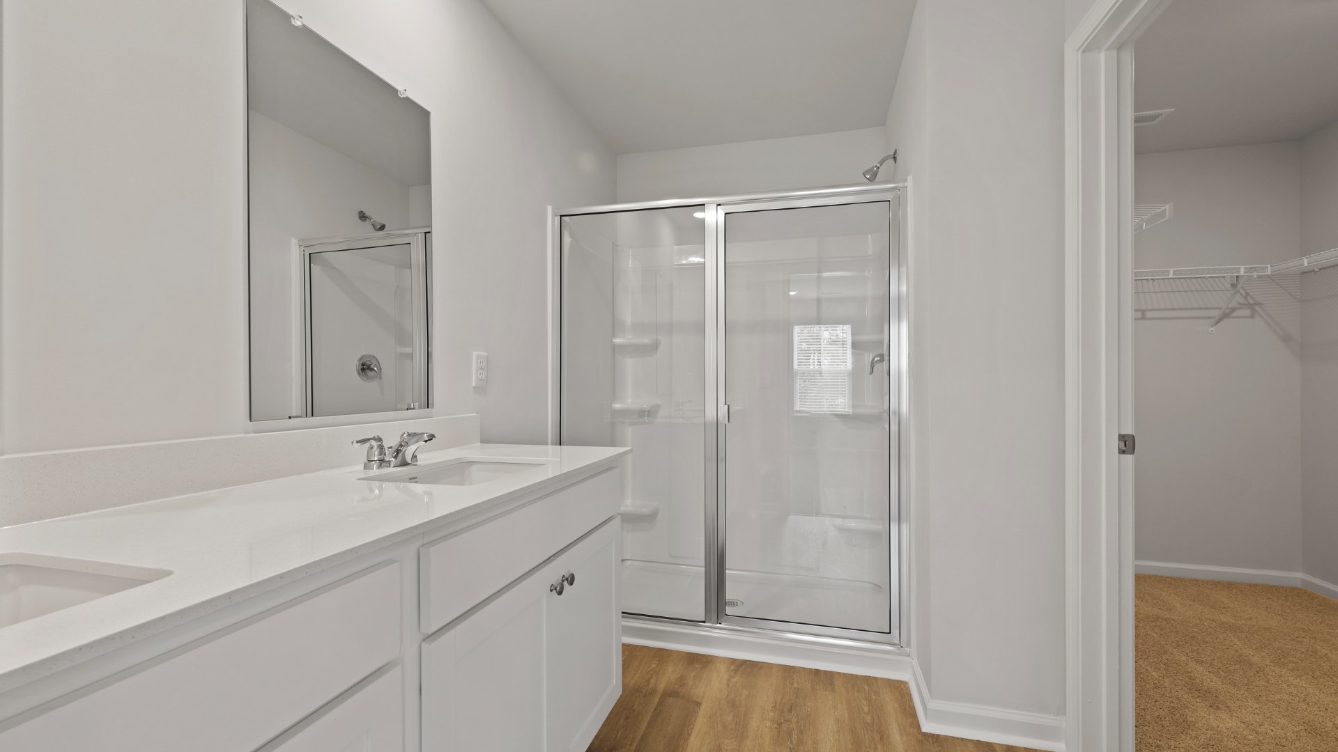 There are double vanities in the primary bathroom as well as a standup walk-in shower and walk-in closet.