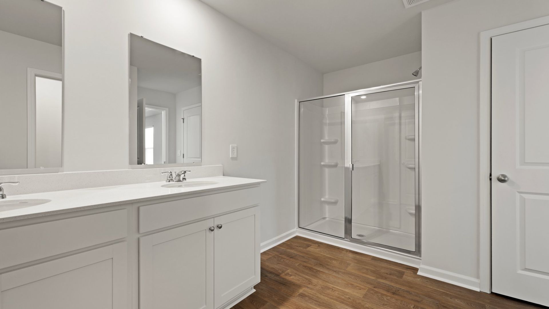 There is two vanities in the private primary bathroom with a standup walk-in shower.