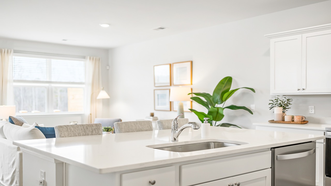 open concept kitchen with white cabinets and quartz