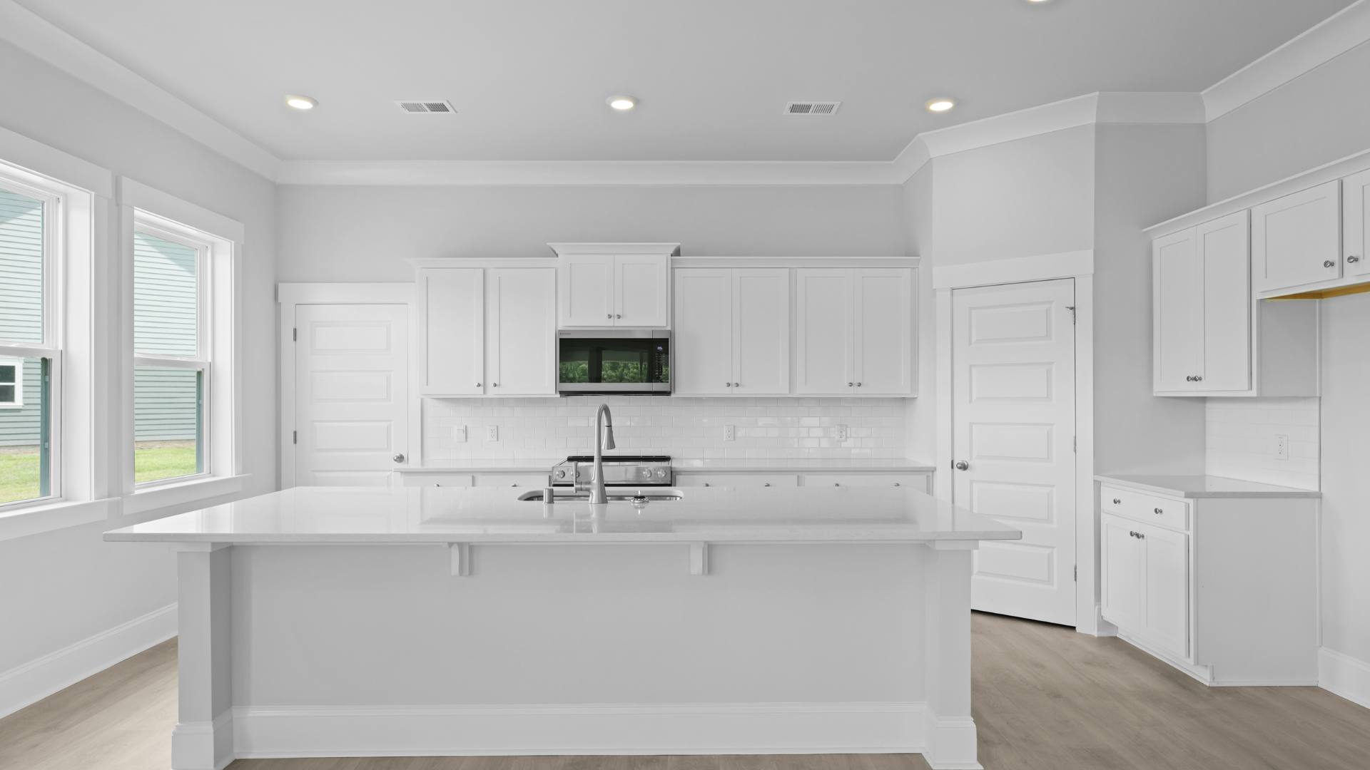 Kitchen with white cabinets, quartz countertops, and modern finishes.