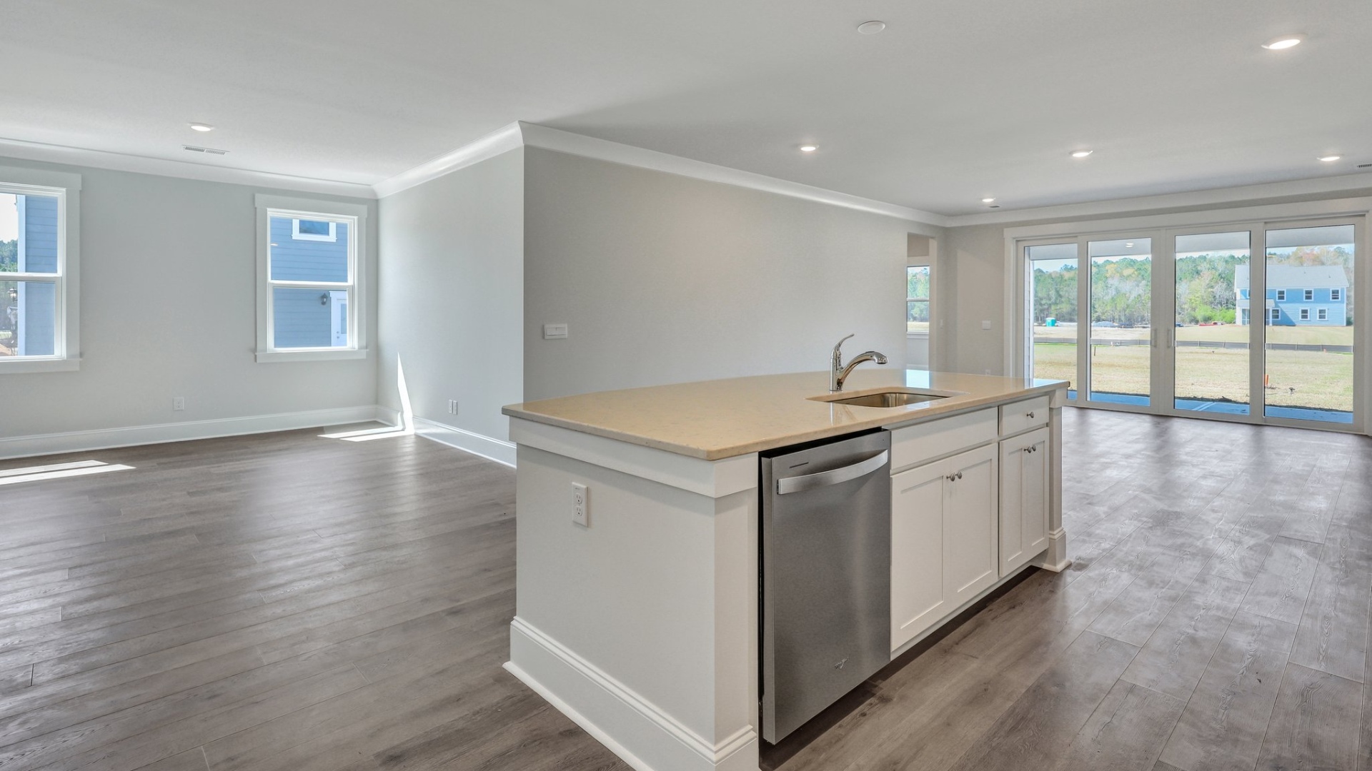 The quartz island in the kitchen has the sink and area for dishwasher.