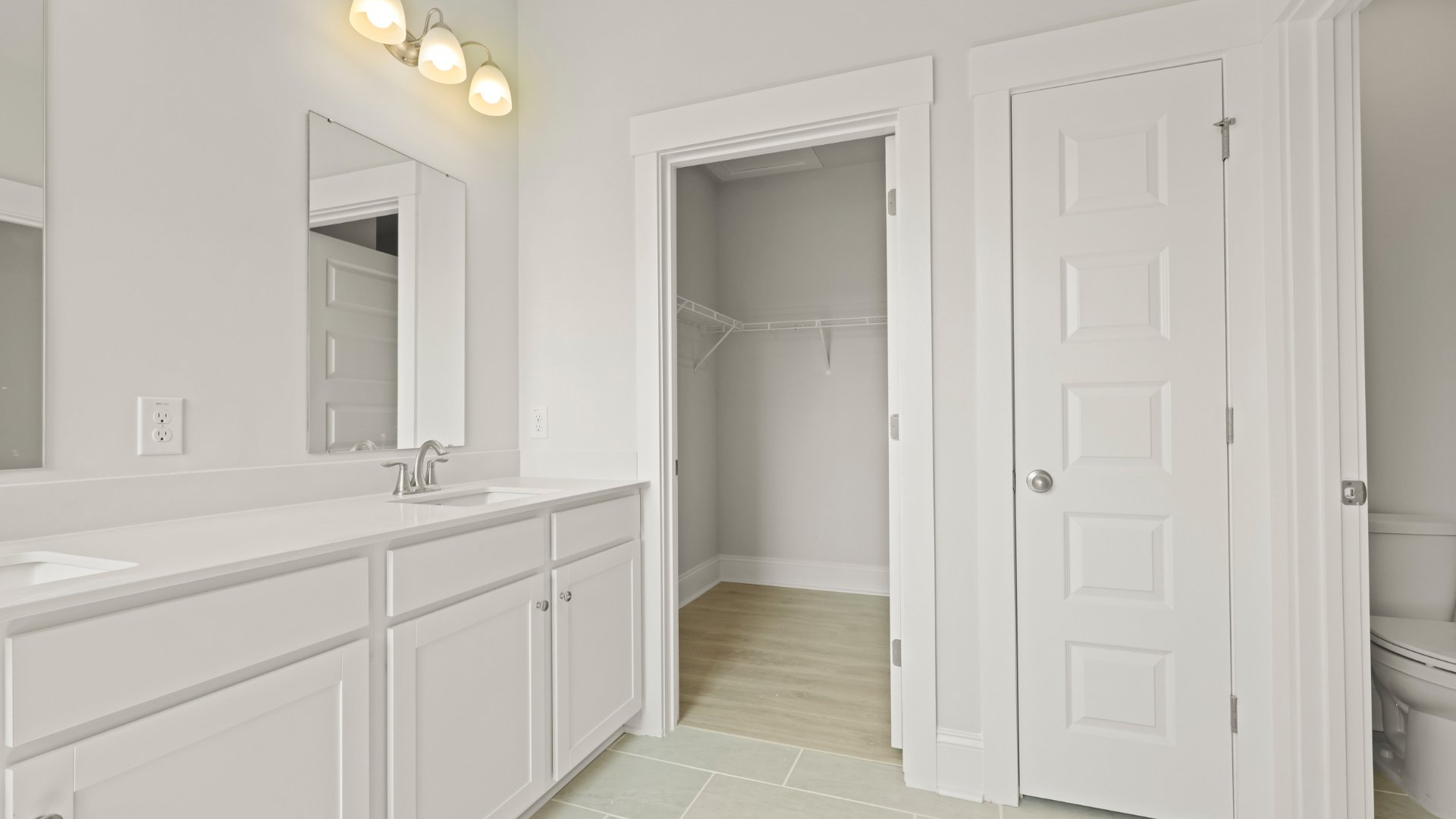 The primary bathroom has double vanities and also holds the closet as well as a seperate room for the toilet offering privacy.