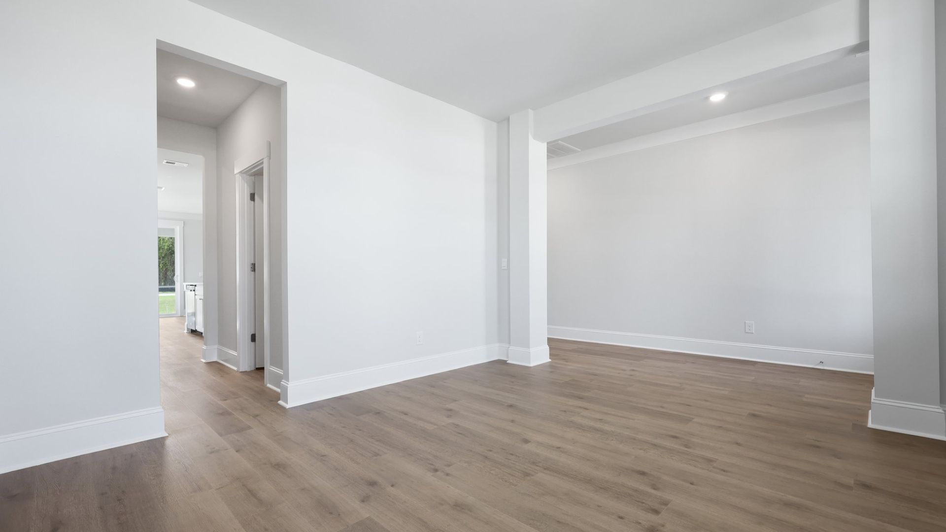 The first floor flex space with a walk through to the kitchen.