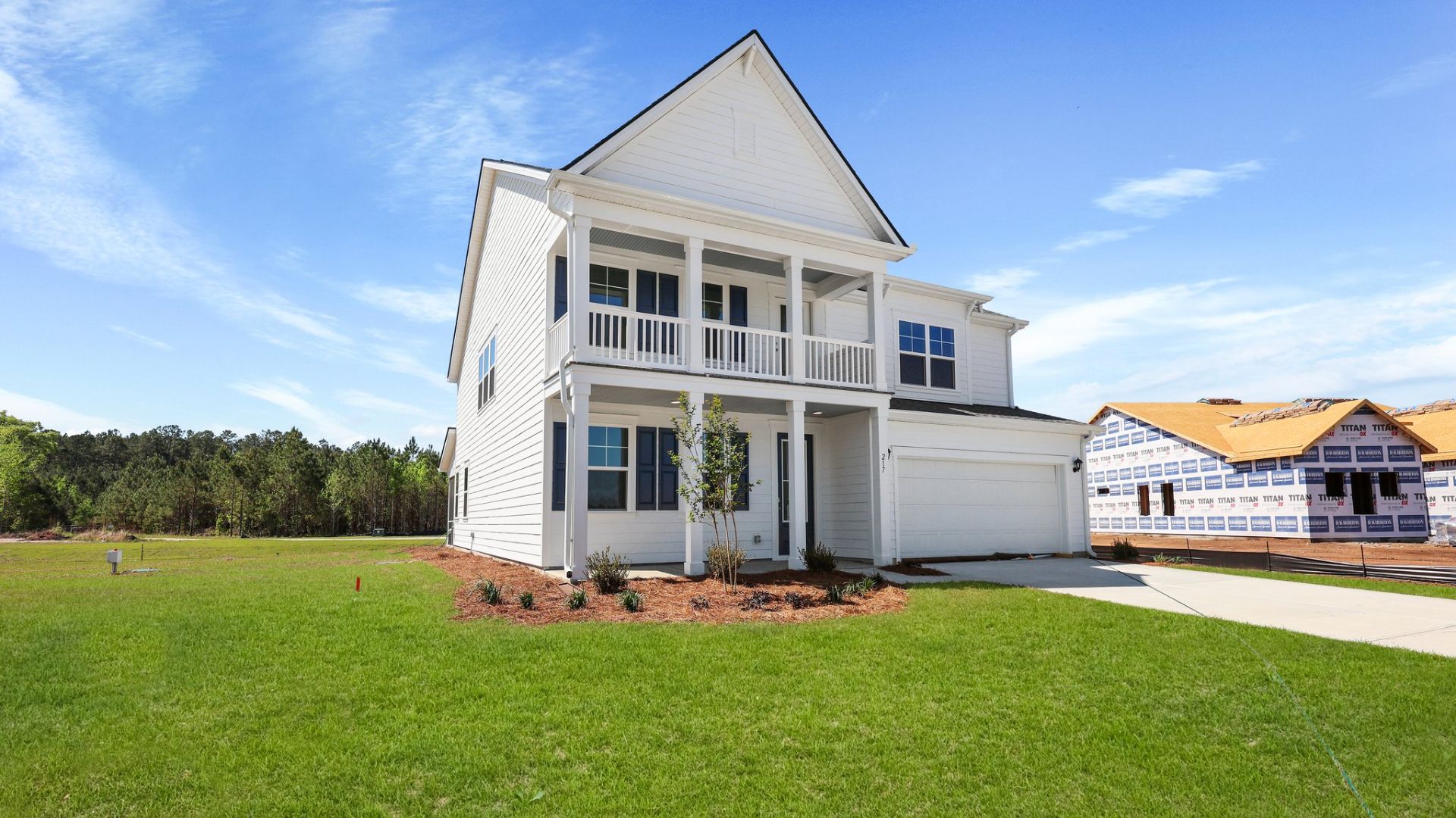 The Harbor Oak with two porches and blue shutters.
