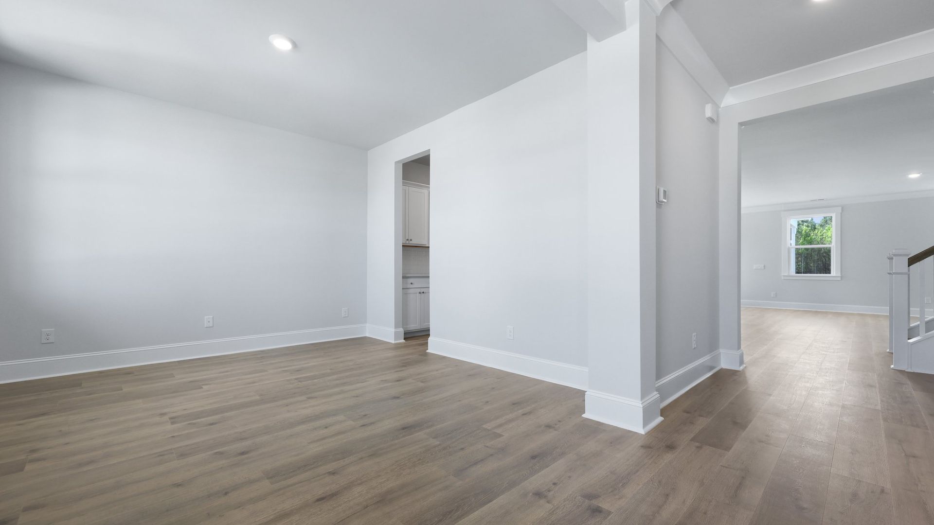 The first floor flex space is has natural lighting from windows and is located near the entry of the house.