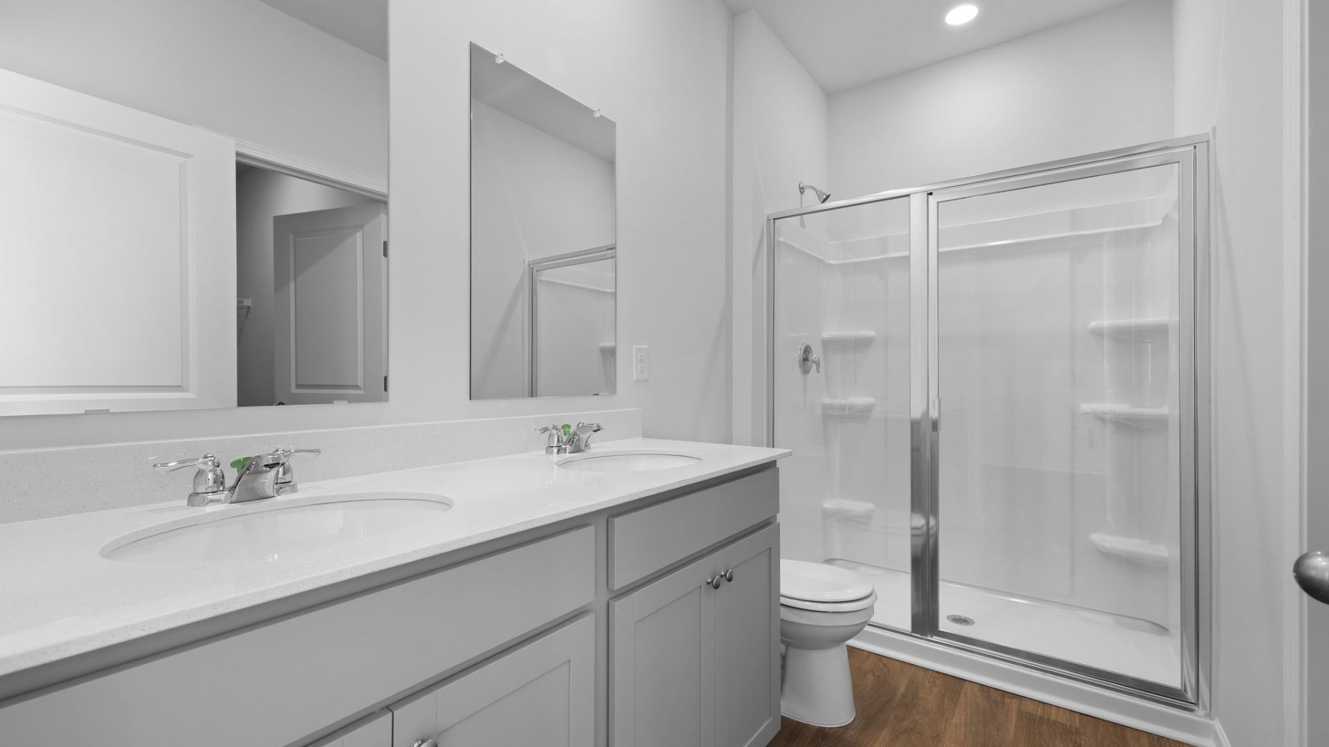 A standup walk-in shower and double vanities are located in the ensuite private primary bathroom.