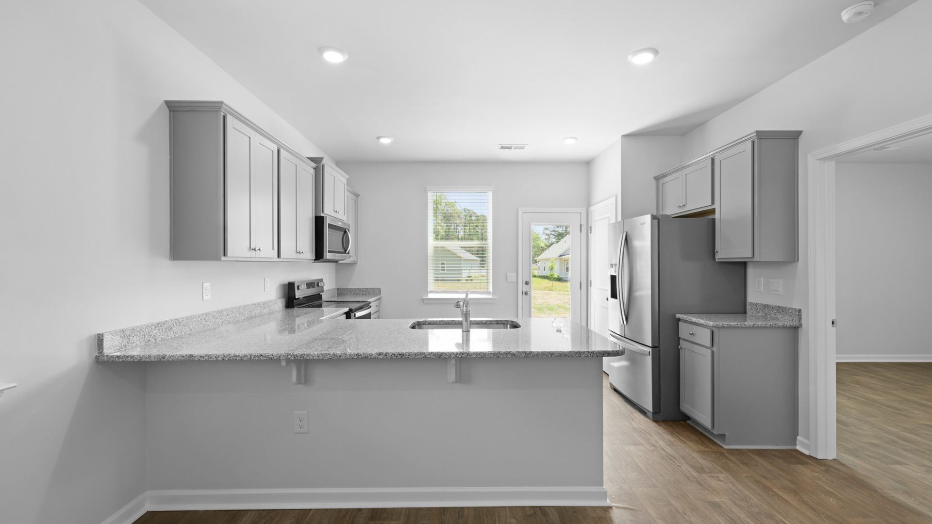 The kitchen offers natural lighting and a peninsular that can fit barstools underneath for extra seating.