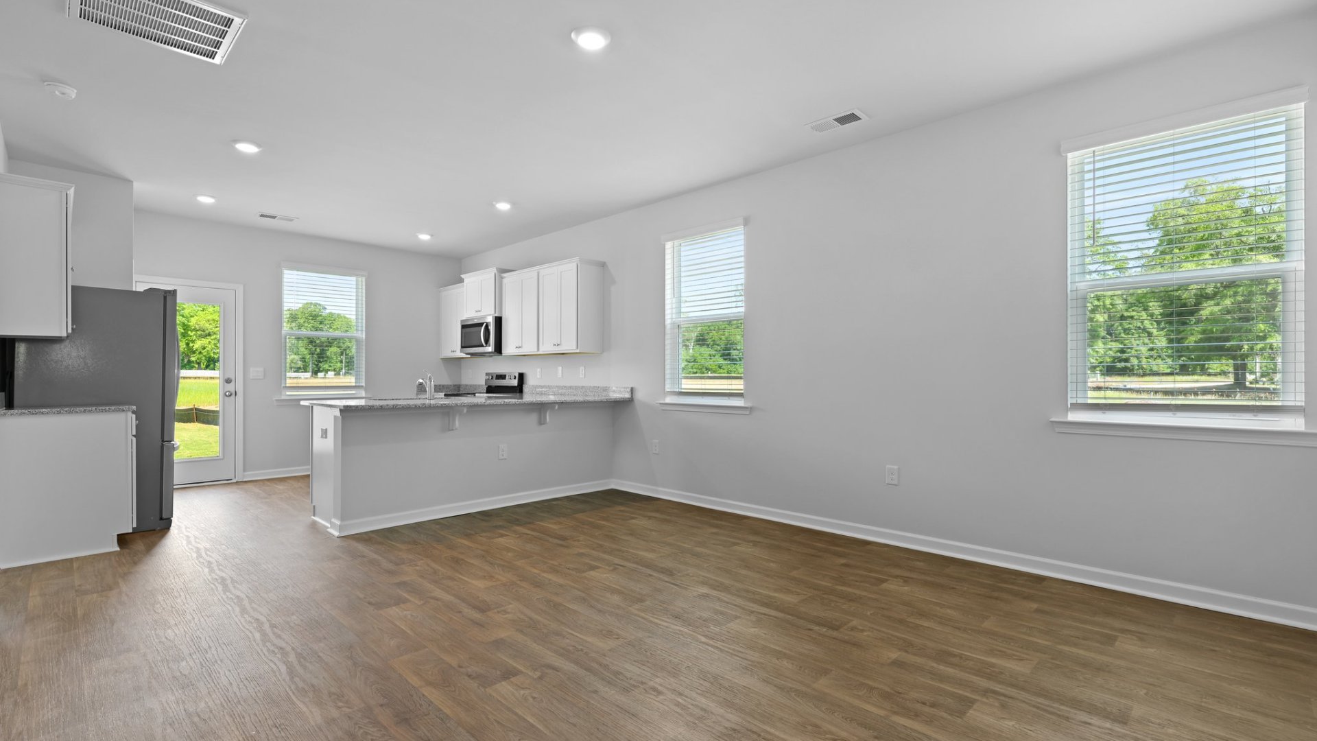 Spacious living area with many windows for natural lighting.