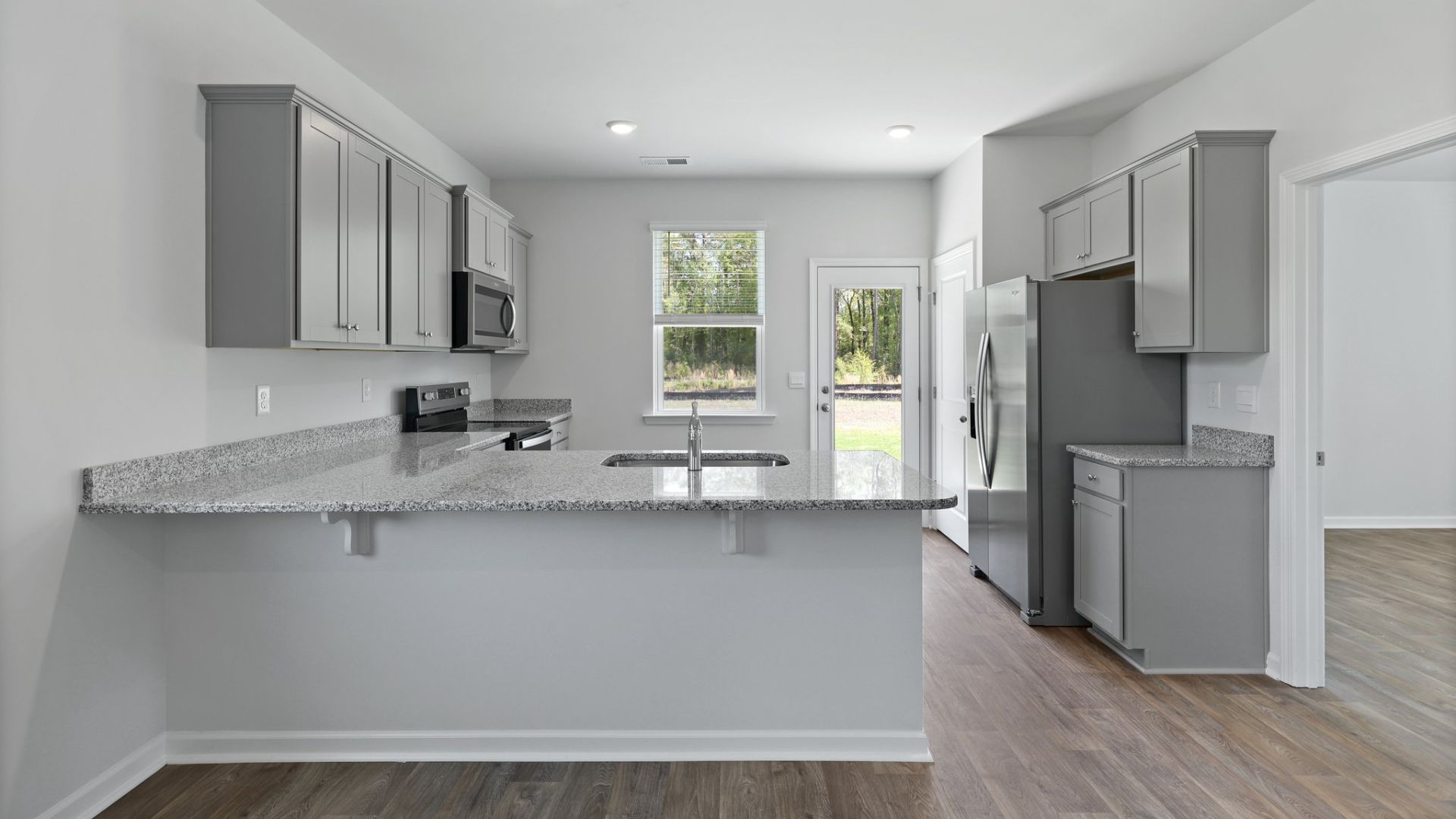 Spacious kitchen and barstools can fit under the peninsula for extra seating.