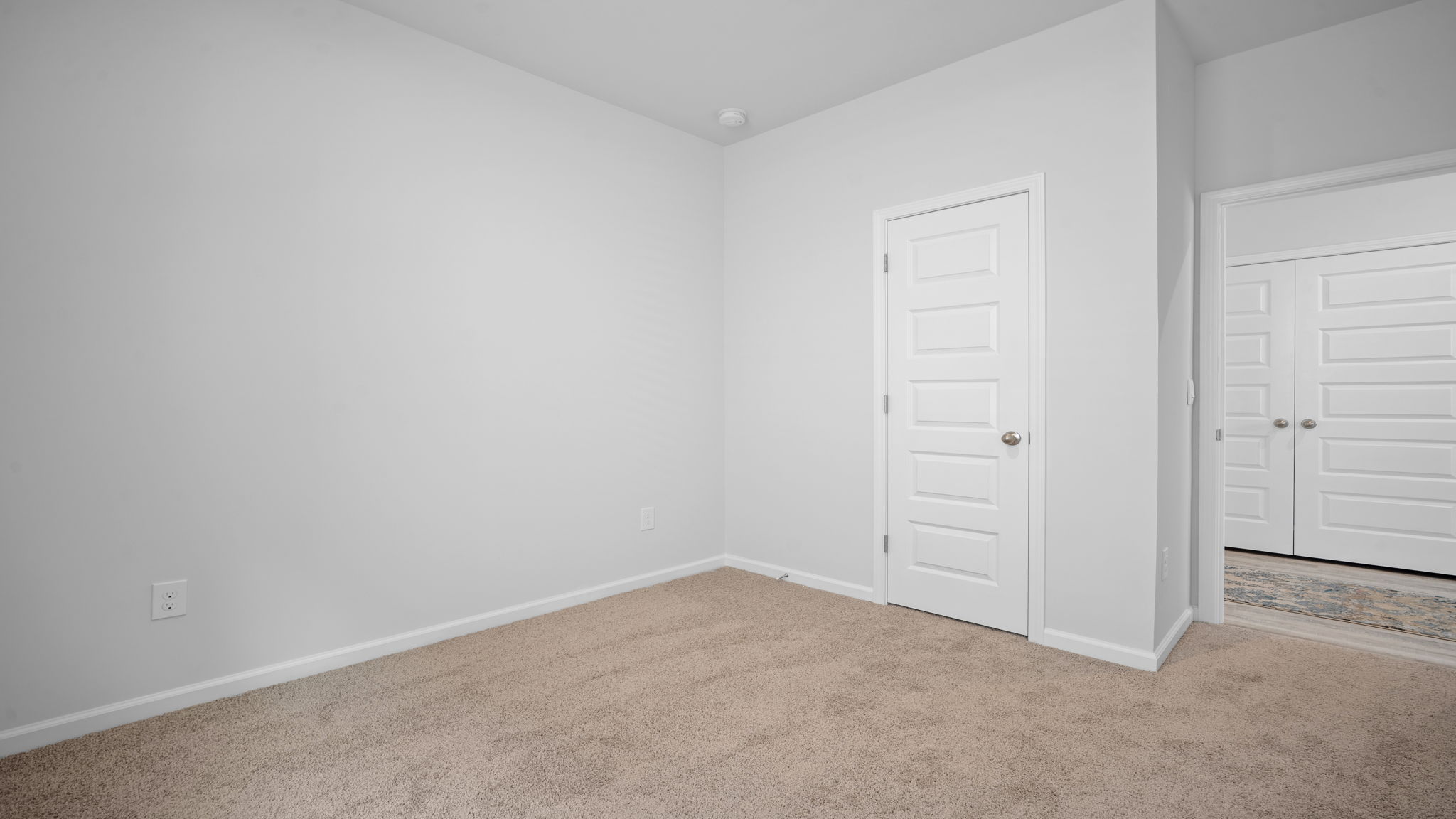 Bright guest bedroom in the Greenbriar home featuring modern finishes and versatile functionality.