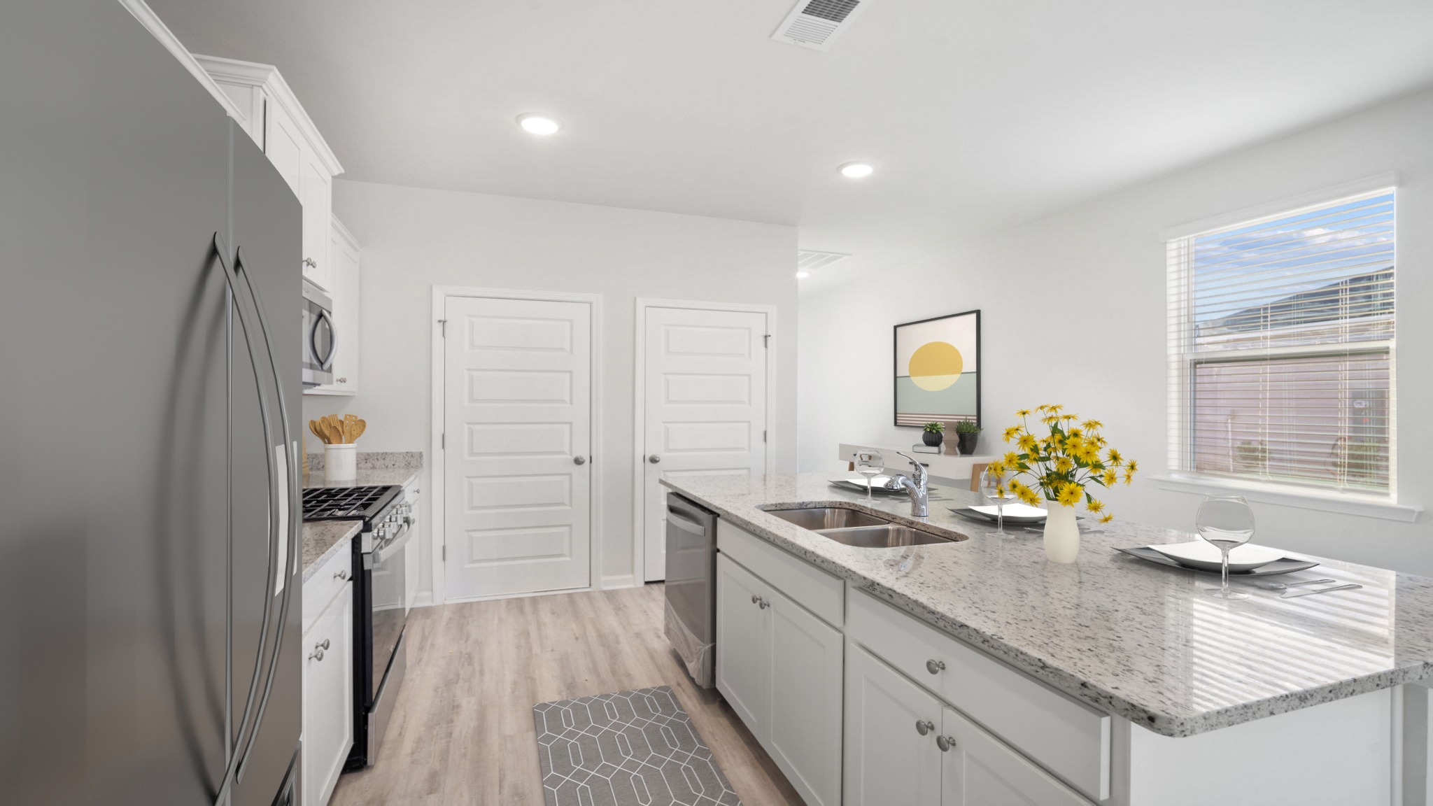 Kitchen island with a double bowl sink, granite countertop, and a dishwasher.