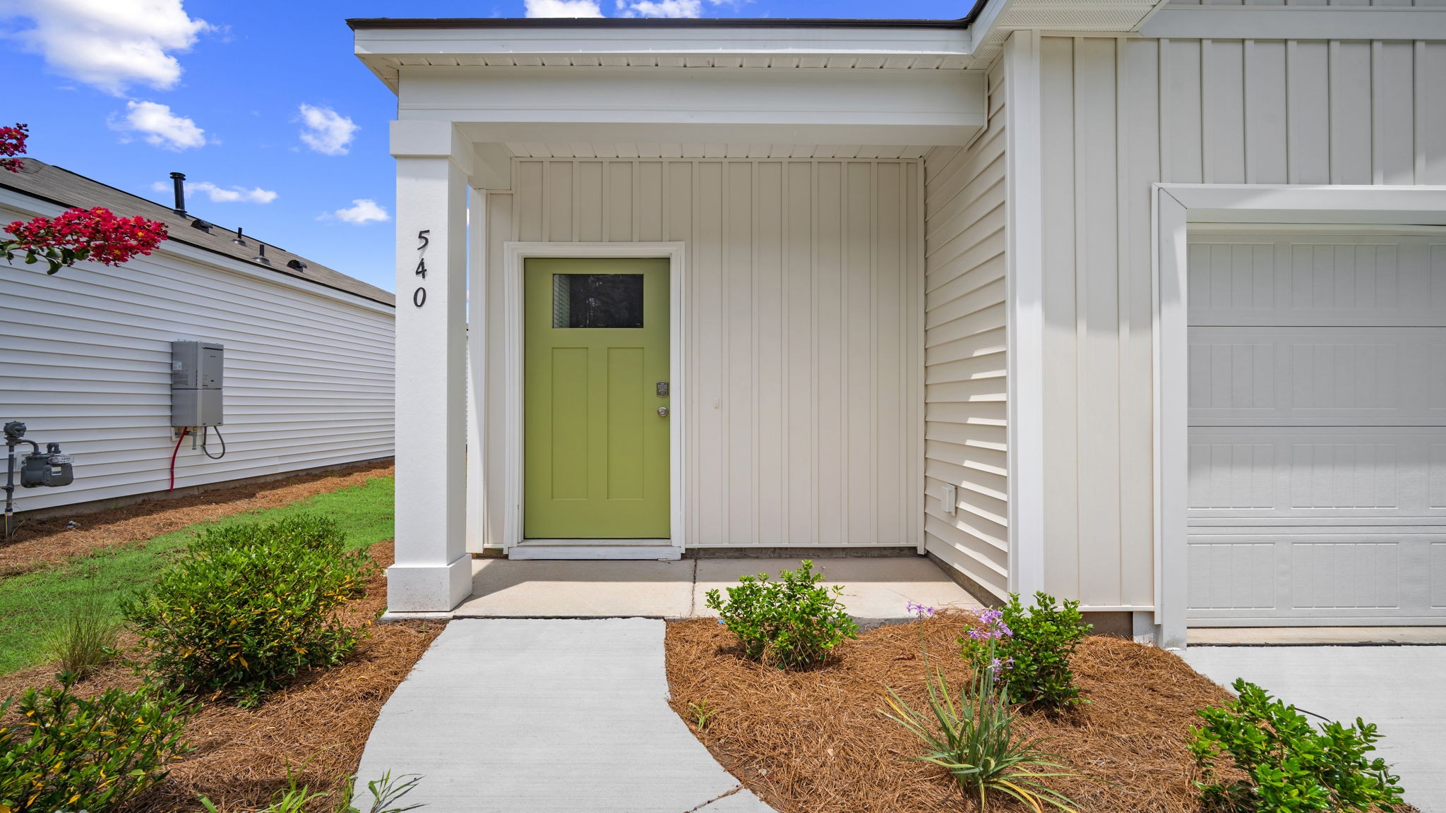 Front door close-up with a porch area and a concrete walk-way from the driveway