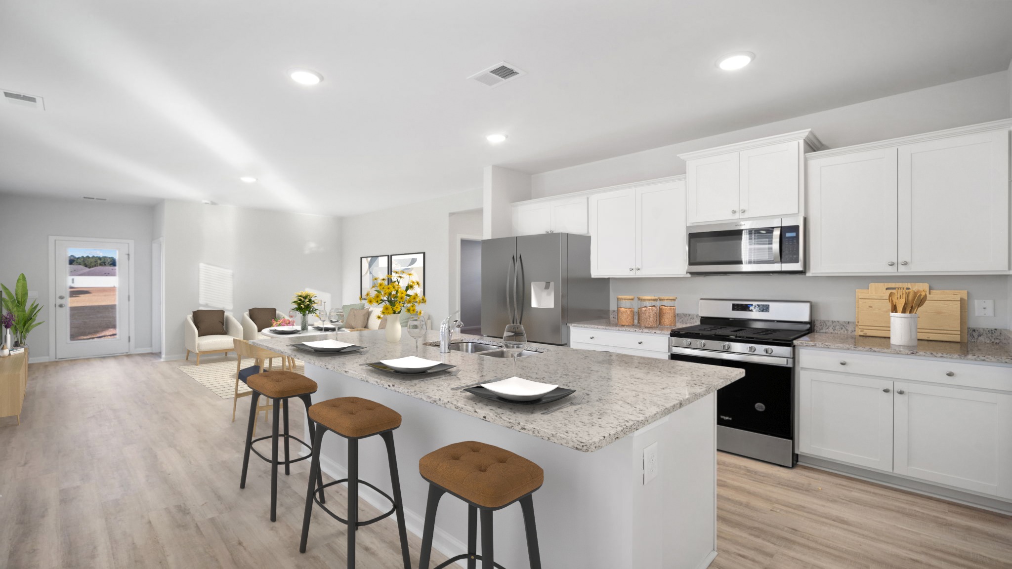 Kitchen with an island that has includes a double sink and vinyl wood flooring.