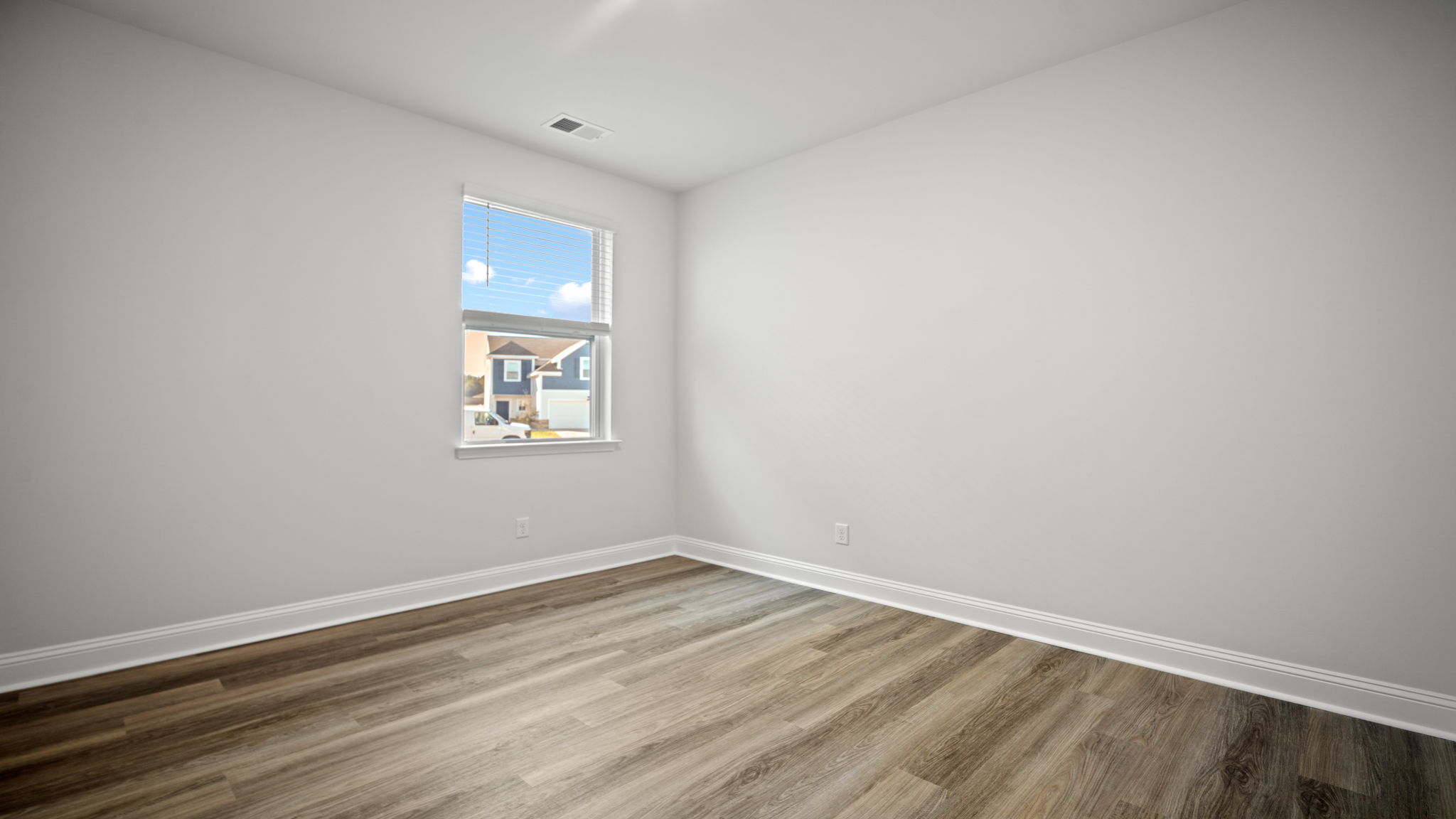 Additional bedroom with large window, neutral color palette, and versatile use for guests, office, or hobby room.