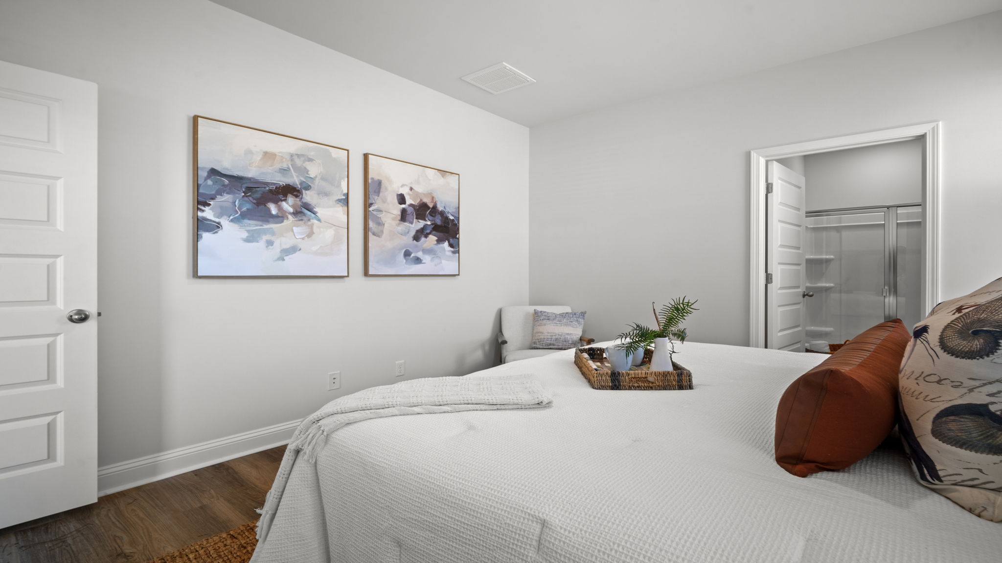 Primary bedroom decorated with a bed, bench and side table