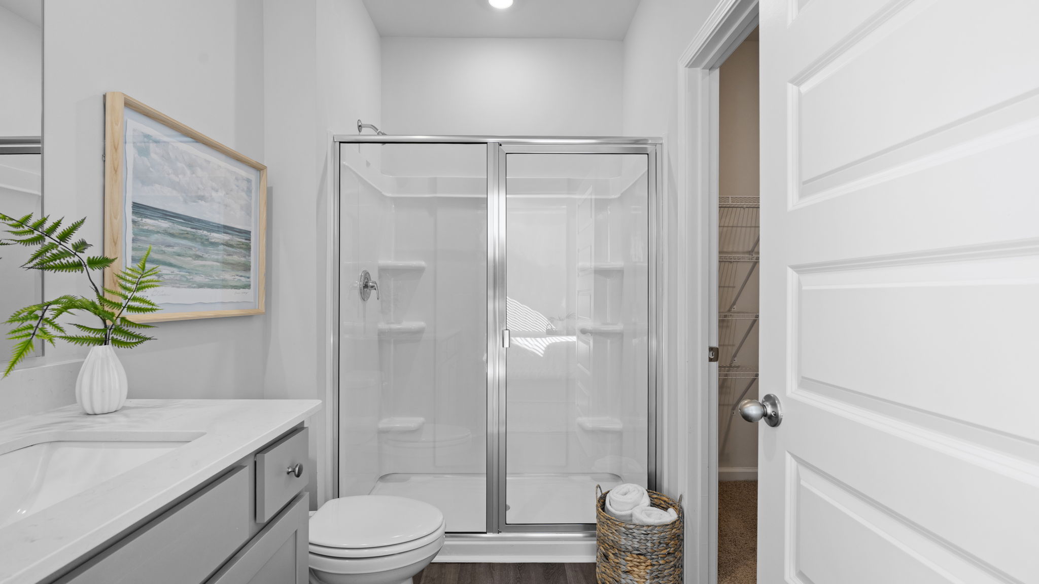 Primary bathroom with dual vanities and walk-in shower in the D.R. Horton Downing