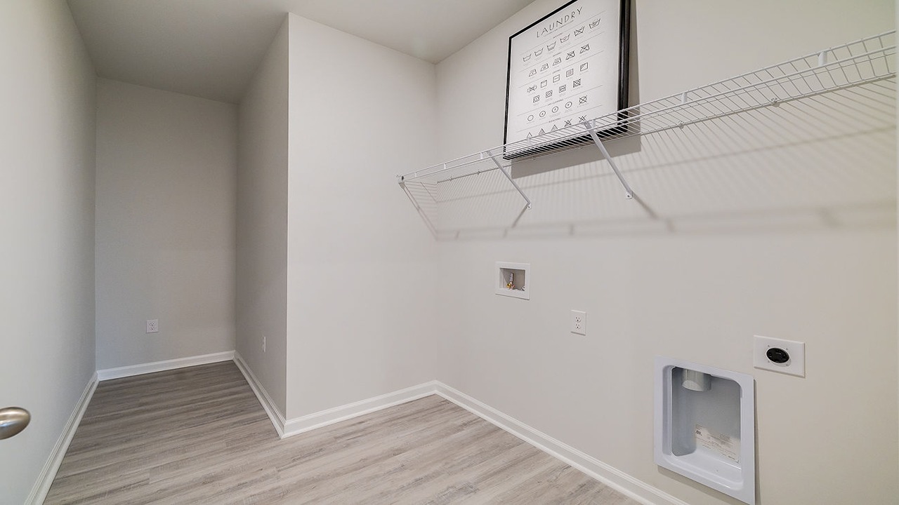 Spacious laundry area has room for a washer and dryer with built in shelves.