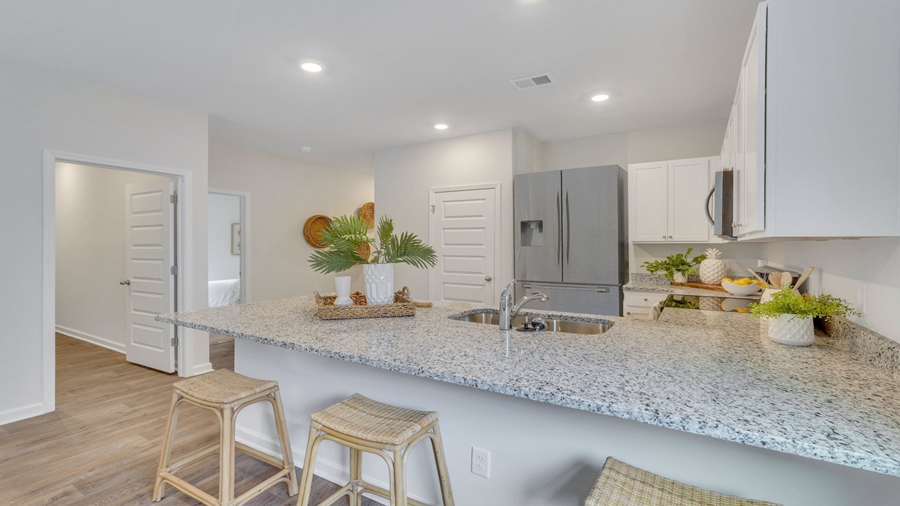 Modern kitchen in the Helena floor plan at East Argent with large island, stainless steel appliances, and ample cabinet space