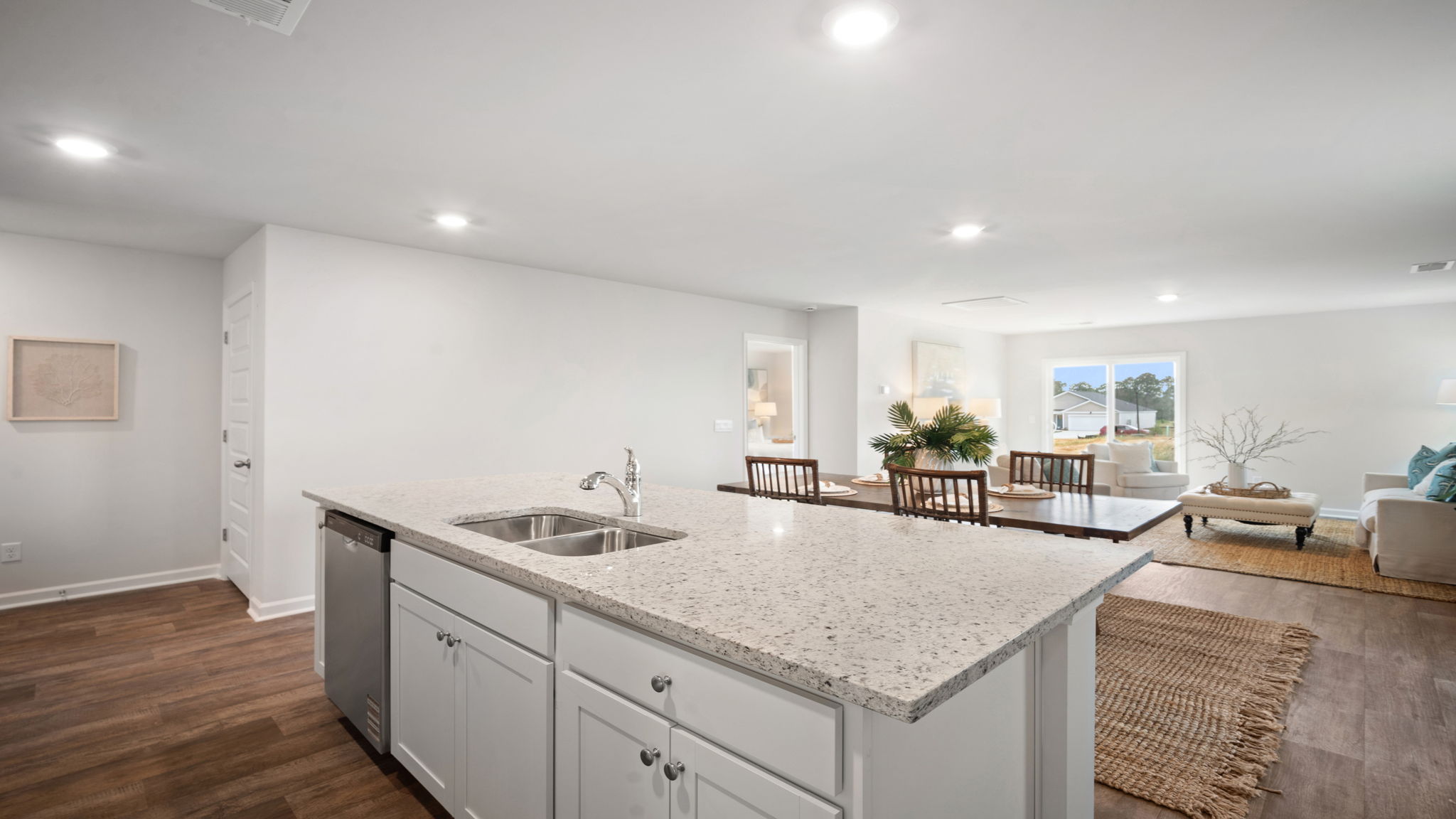 Kitchen walkway with counters on both sides and a stainless dishwasher in the island