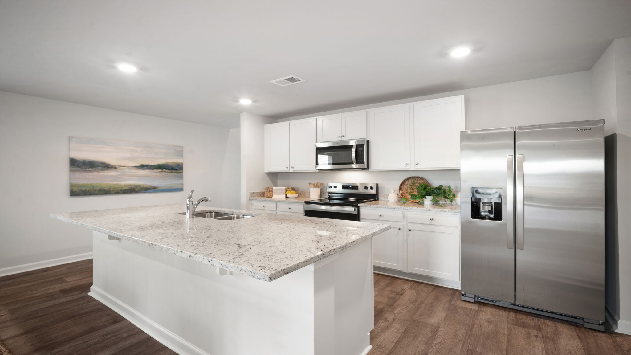 Kitchen walkway with counters on both sides and a stainless dishwasher in the island