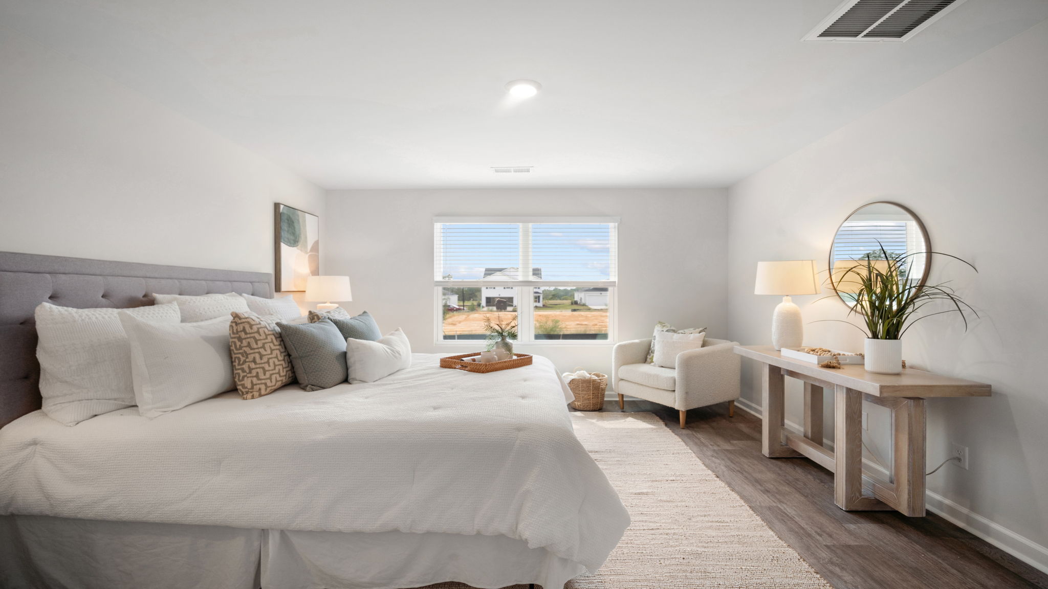 Primary bedroom with carpeted floors, large windows, and trey ceilings.