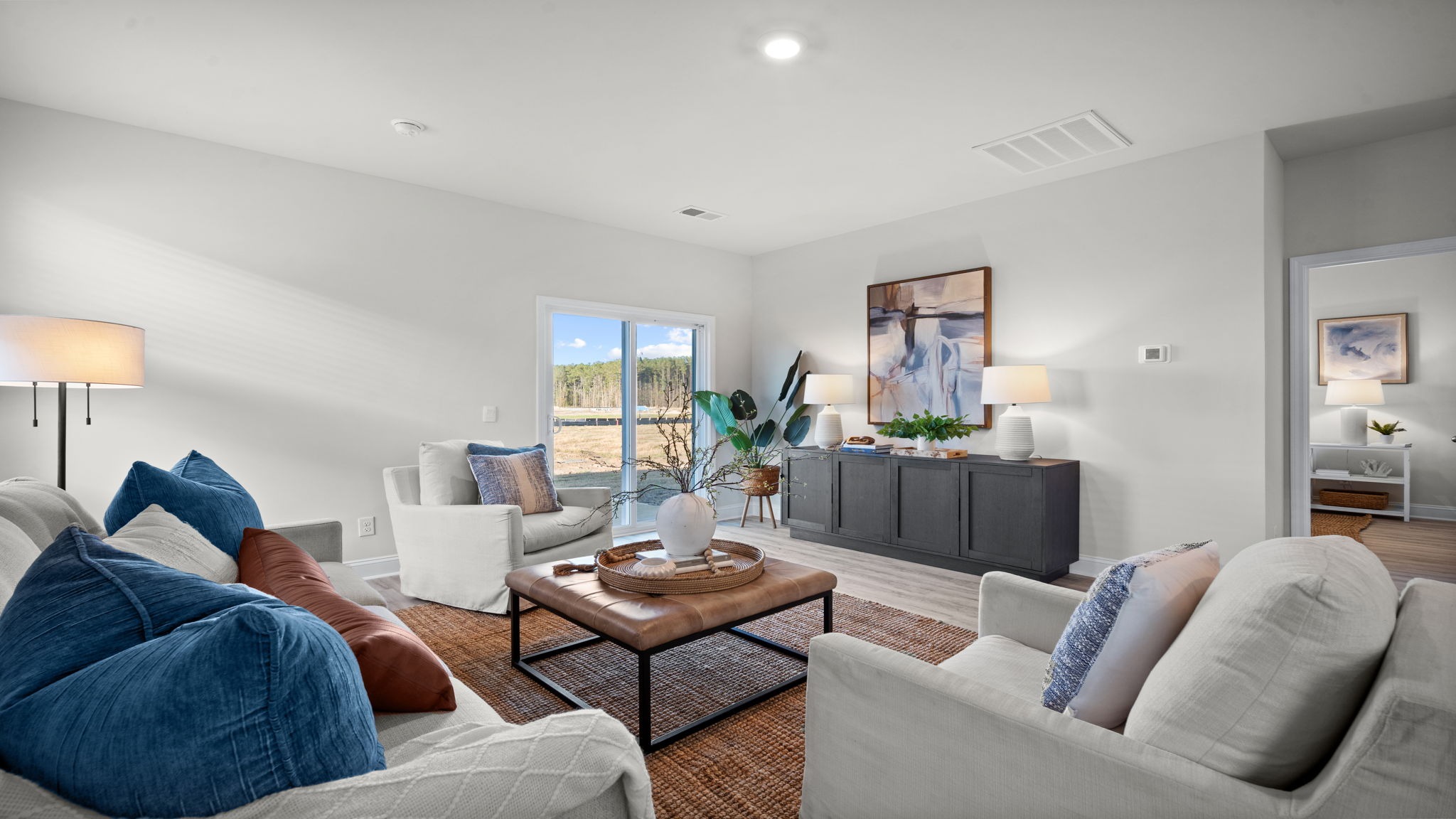 “Spacious open concept living room in Manning DR Horton home connected to kitchen and dining area, perfect for entertaining.”