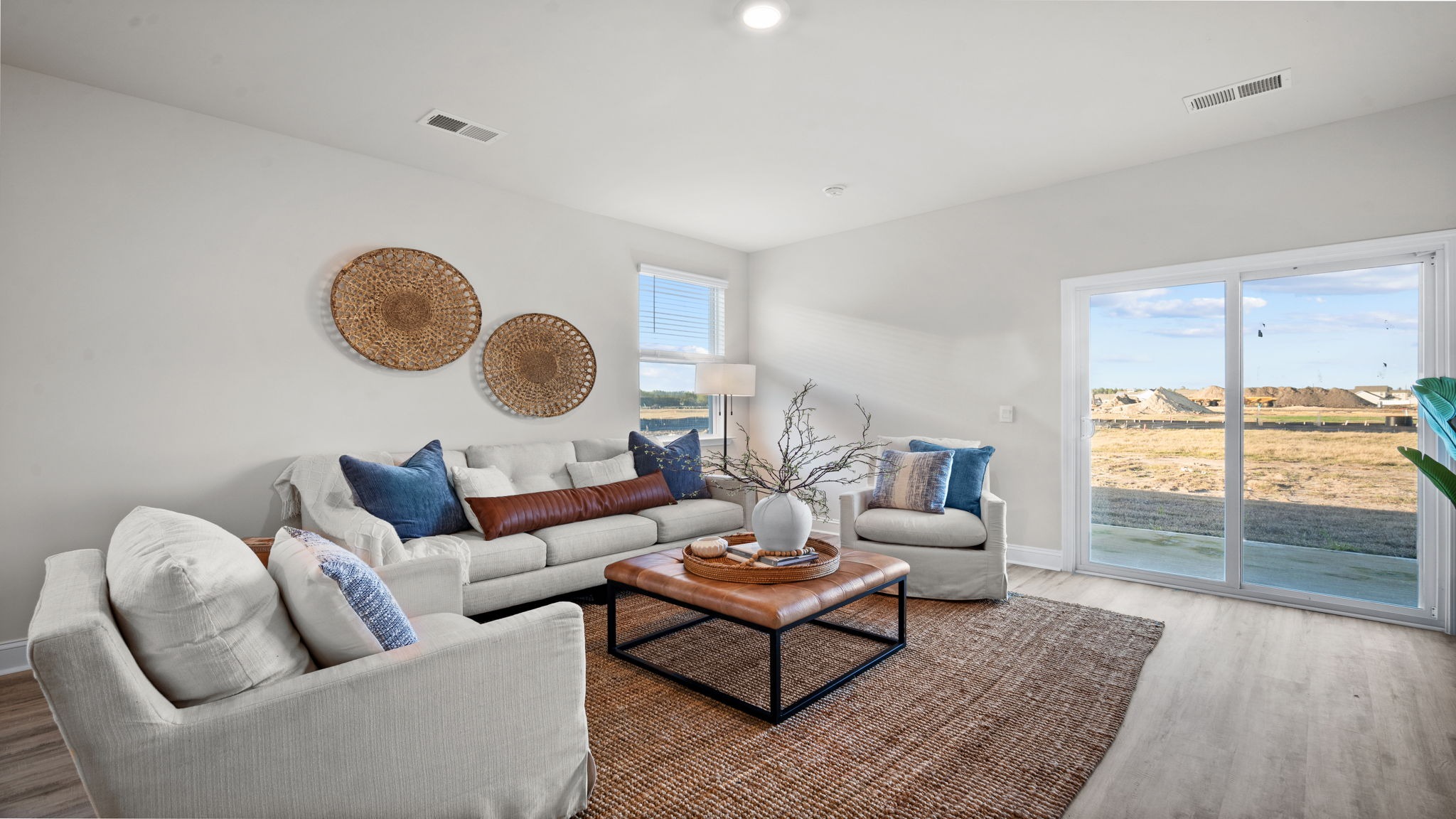 “Spacious open concept living room in Manning DR Horton home connected to kitchen and dining area, perfect for entertaining.”