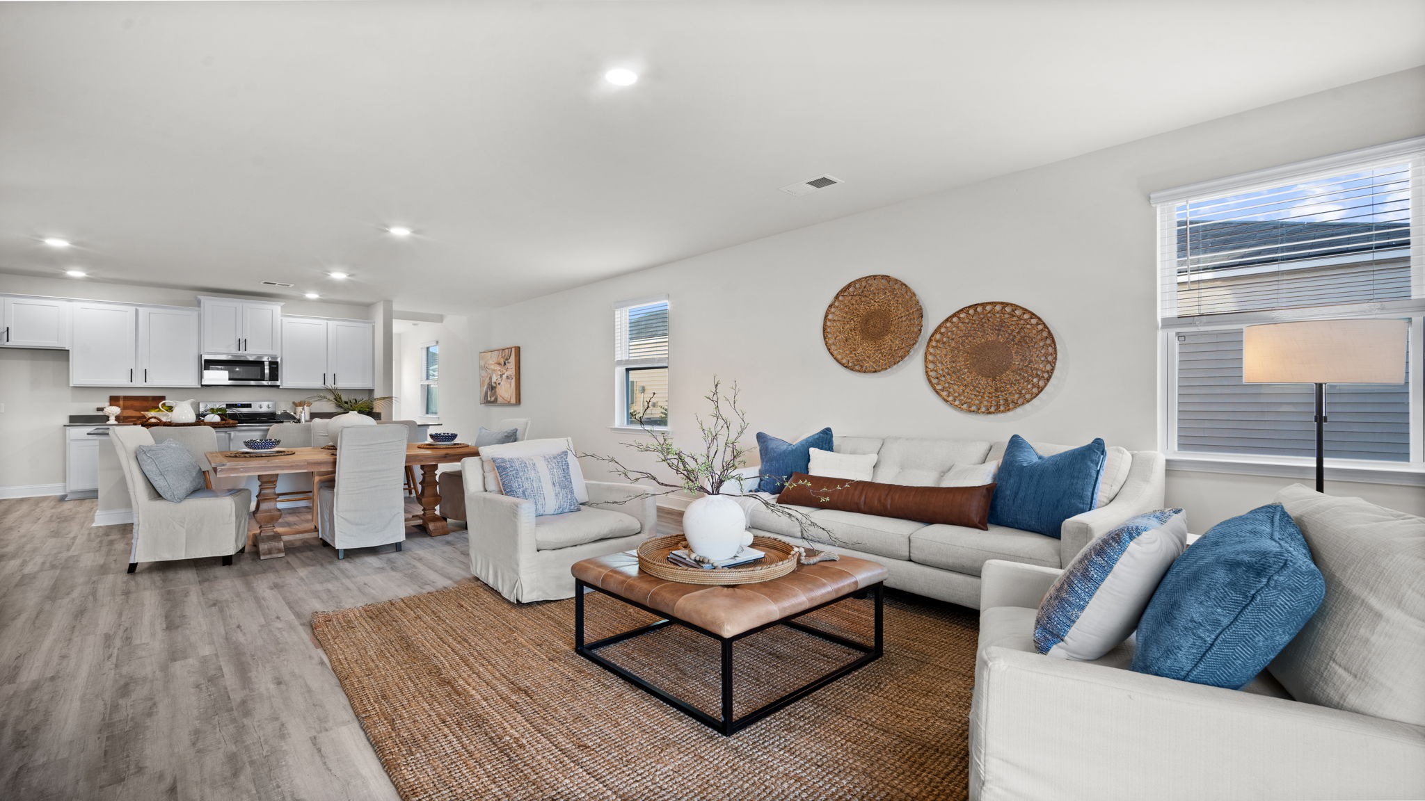 “Spacious open concept living room in Manning DR Horton home connected to kitchen and dining area, perfect for entertaining.”