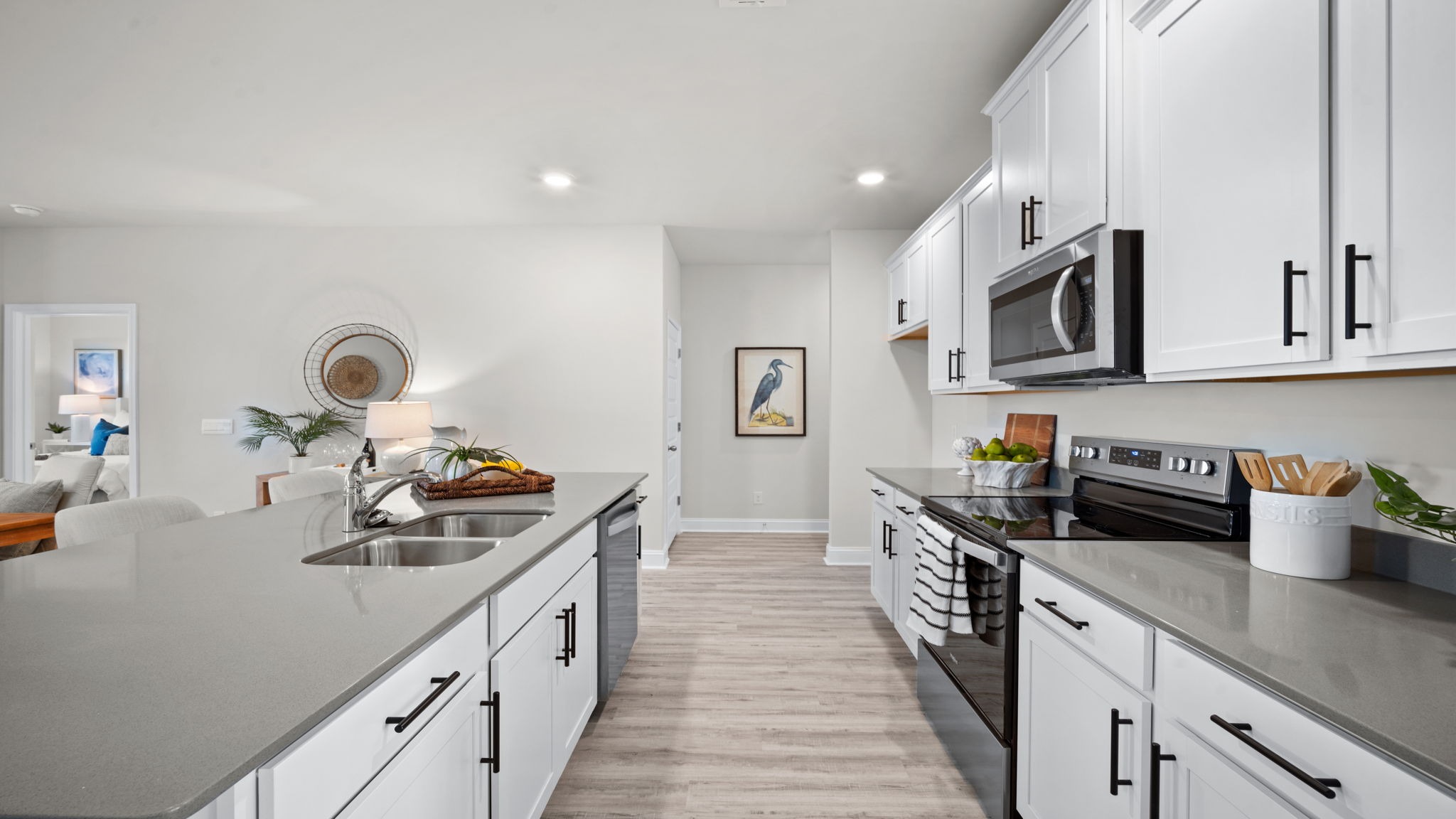 “Modern kitchen in Manning floor plan featuring large center island, natural gas appliances, and open layout for entertaining.”