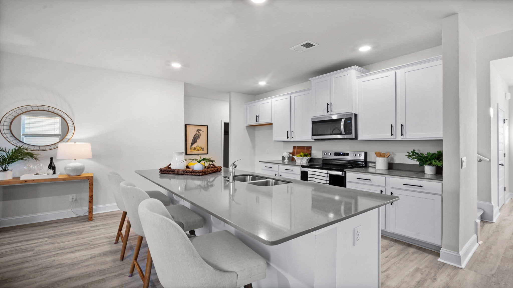 “Modern kitchen in Manning floor plan featuring large center island, natural gas appliances, and open layout for entertaining.”