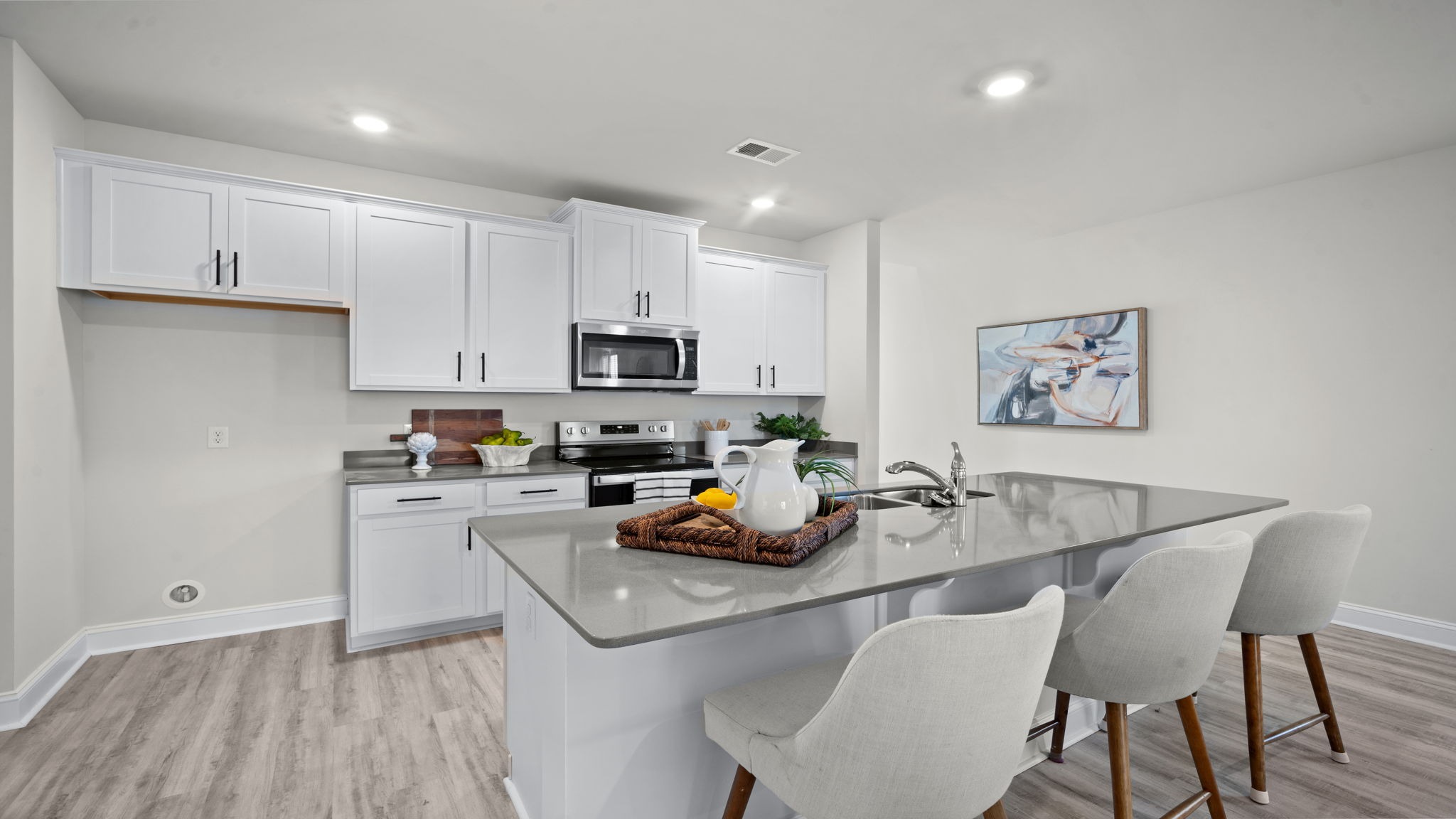 “Modern kitchen in Manning floor plan featuring large center island, natural gas appliances, and open layout for entertaining.”